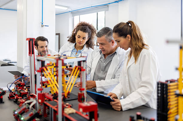 Robotics Latin American teacher teaching a class to a group of post-graduate engineering students - education concepts